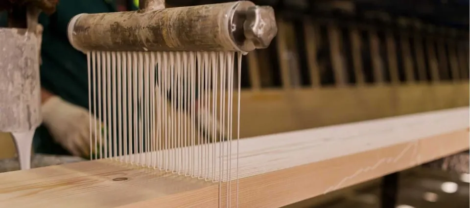 Applying adhesive to a timber lamella